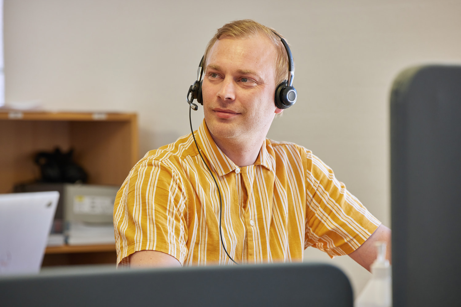 A man is looking to the side while wearing a headset.